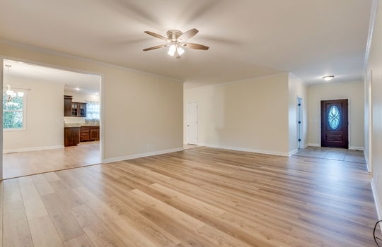 living room, hardwood flooring, ceiling fan, entryway, tile flooring, front door, doorway to kitchen
