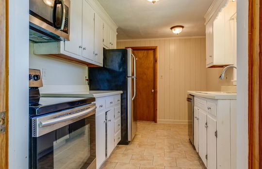 kitchen, built in microwave, oven/range, cabinets, countertops, refrigerator, dishwasher, sink, tile flooring
