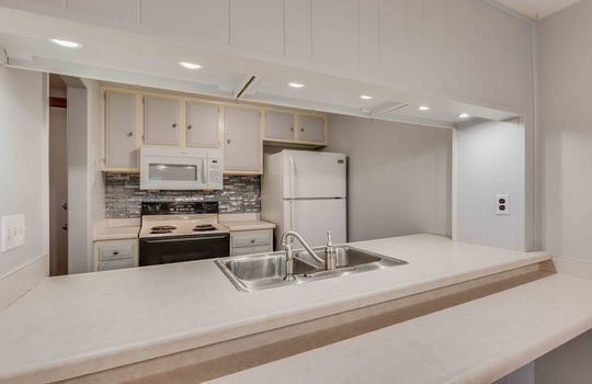 bar seating, countertops, sink, refrigerator, oven/range, built-in microwave, backsplash, cabinets, countertops