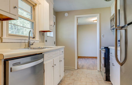 kitchen, tile flooring, dishwasher, sink, refrigerator, stove/oven, microwave, cabinets, countertops, exterior door