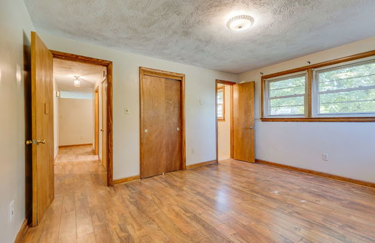 primary bedroom, window, closet, door to bath, laminate flooring