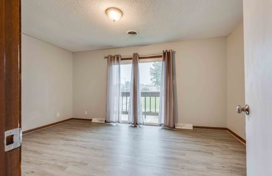 bedroom, sliding door to private balcony, vinyl flooring