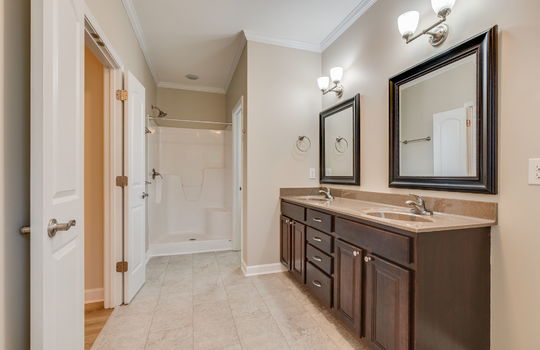 primary bathroom, double vanity sink, shower, tile flooring