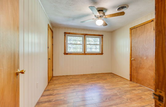 bedroom, laminate flooring, paneling walls, closet, ceiling fan, windows