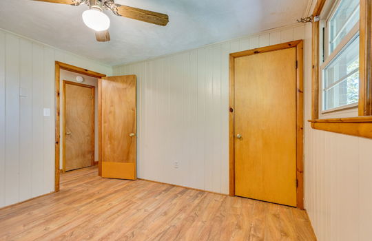 bedroom, laminate flooring, paneling walls, closet, ceiling fan, windows