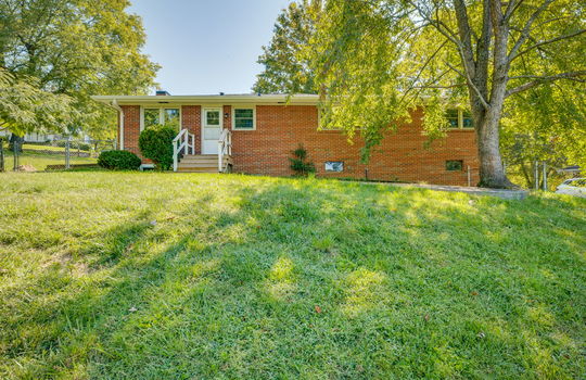 back of home, brick ranch for lease, back yard, trees, landscaping, front steps, storm door, front door, windows