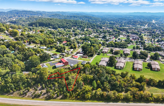 aerial view of property, property outline, nearby homes, nearby businesses, wooded property, mountains