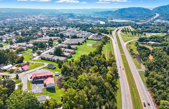 Aerial view of property, wooded property, interstate, mountain views, nearby homes/businesses