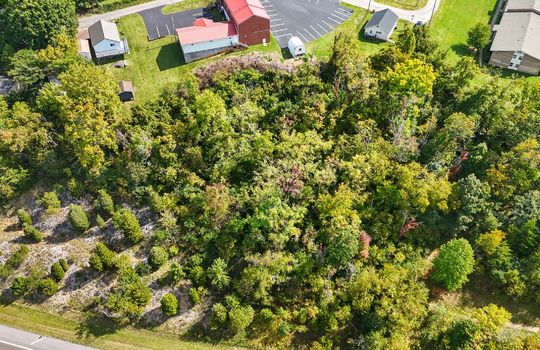 aerial view of property, interstate nearby, wooded property, nearby homes/businesses