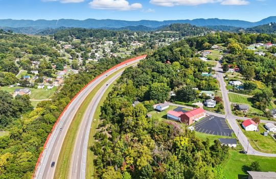 Aerial view of property, wooded property, interstate, mountain views, nearby homes/businesses