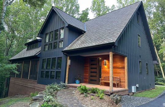 contemporary home, wood siding, metal siding, trees, driveway, screened porch, landscaping, front door