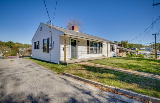 driveway, ranch style home, front porch, front door, storm door, vinyl siding, sidewalk, front yard