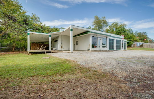 contemporary home for lease, gravel driveway, metal siding, covered patio, covered back porch, fencing