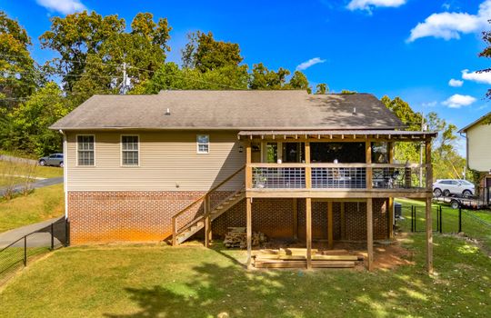 ranch style home, back of home, back yard, back deck, back door, fencing, vinyl siding, driveway