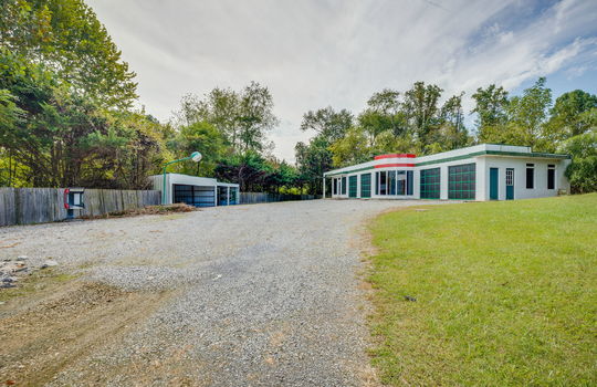 contemporary home for lease, metal siding, windows, carport/garage, gravel driveway