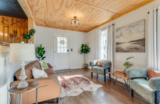 living room, front door, luxury vinyl flooring, beadboard ceiling, windows