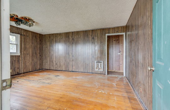 living room, fixer upper, ceiling damage, windows, front door, hardwood flooring, paneling walls