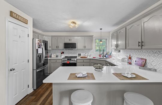 kitchen, pantry, stainless appliances, refrigerator, built-in microwave, stove, dishwasher, granite countertops, backsplash, cabinets, windows, luxury vinyl flooring