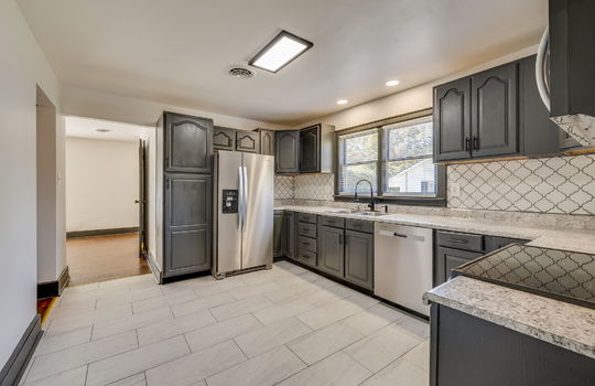 kitchen, tile backsplash, cabinets, countertops, tile flooring, stainless appliances, refrigerator, dishwasher, built-in microwave, oven/range, sink, window above sink