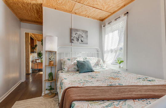 bedroom, luxury vinyl flooring, beadboard ceiling, window, door to living room