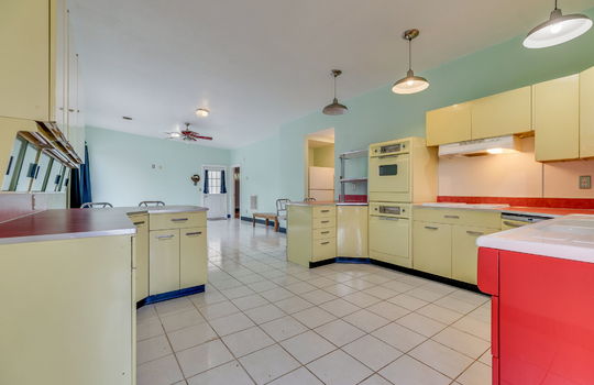 kitchen view toward side door, metal cabinets, wall oven, cooktop, dishwasher, sink, ceiling fan