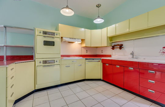 kitchen, tile flooring, 1950s metal cabinets, sink, wall ovens, dishwasher, cooktop