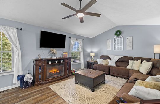 living room, vaulted ceiling, ceiling fan, windows, laminate flooring