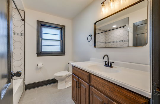 bathroom, tile shower surround, shower/tub, toilet, sink, window, tile flooring