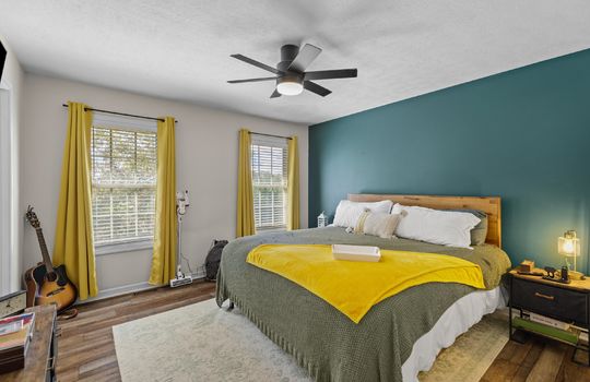 primary bedroom, laminate flooring, windows, ceiling fan