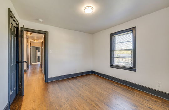bedroom, hardwood flooring, window, door to hallway