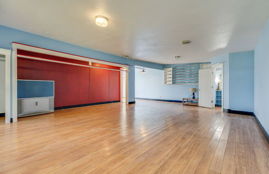living room, laminate flooring, door to half bath, built in shelving