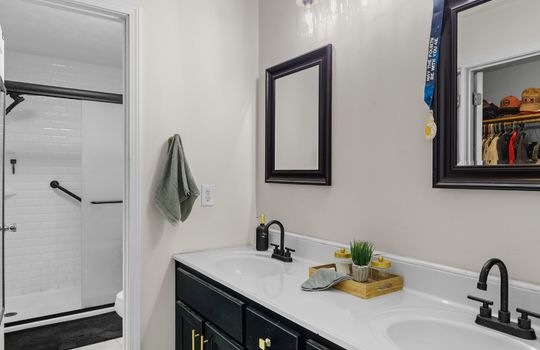 primary bathroom, tile flooring, double vanity, tile shower, toilet