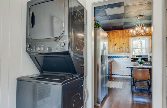 laundry space, luxury vinyl flooring, beadboard ceiling, door to kitchen
