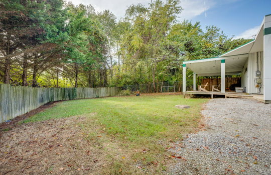 back yard, vencing, covered back deck, gravel driveway, metal siding