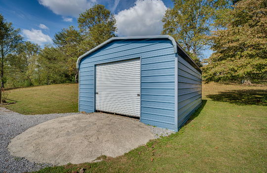 garage, detached garage, metal siding, metal roof, yard, gravel driveway