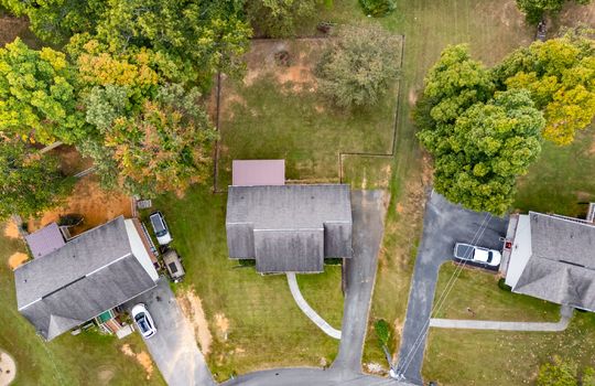 aerial overhead view of home, front yard, sidewalk, roof, driveway, fenced back yard, covered back deck
