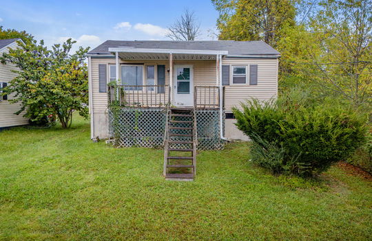 Bungalow home, fixer upper, vinyl siding, covered front porch, front door, front yard