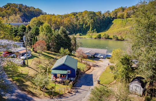 aerial photo of home, fencing, neighboring homes, views of Boone Lake, mountain views, metal roof, covered front porch, storage shed