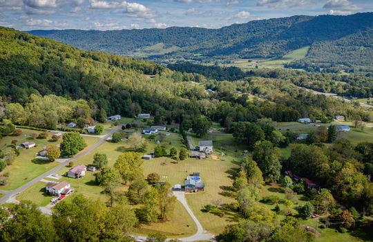 Aerial photo of property, driveway, yard, front yard, back yard, trees, above ground pool, neighboring homes, mountains