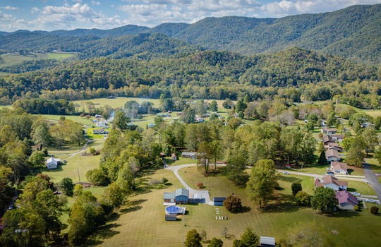 Aerial photo of property, driveway, yard, front yard, back yard, trees, above ground pool, neighboring homes, mountains
