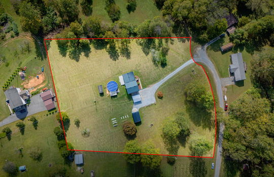 Aerial photo of property, property outline, driveway, yard, front yard, back yard, trees, above ground pool, neighboring homes