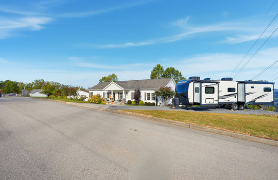 modular home, detached garage, driveway, covered front porch, mountain views, RV parking, street, road