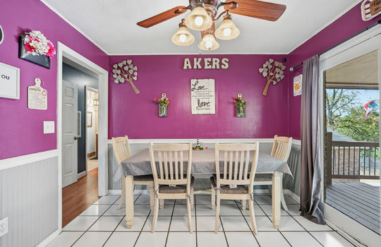 dining space, door to back deck, tile flooring, ceiling fan, wainscoting