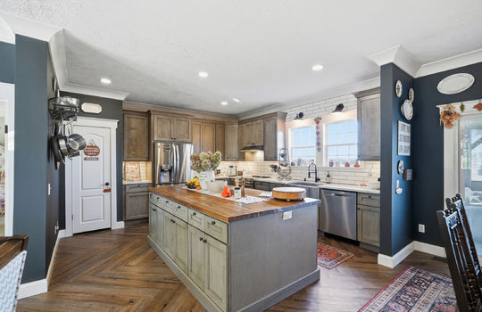kitchen, island w/ butcher block countertop, stainless steel appliances, dishwasher, oven/range, refrigerator, sink, windows, mountain views, pantry, tile backsplash