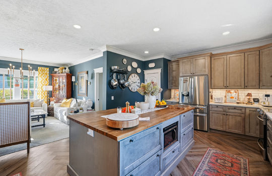 kitchen, open floorplan, 8ft kitchen island, butcher block countertop, stainless appliances, luxury cabinetry, quartz countertops, refrigerator, microwave, oven/range, tile backsplash