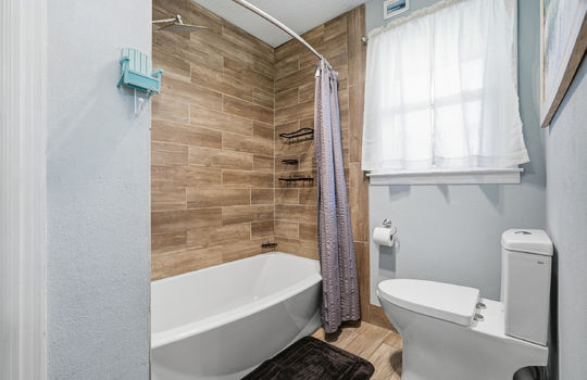 tile shower surround, shower/tub, toilet, tile flooring, window