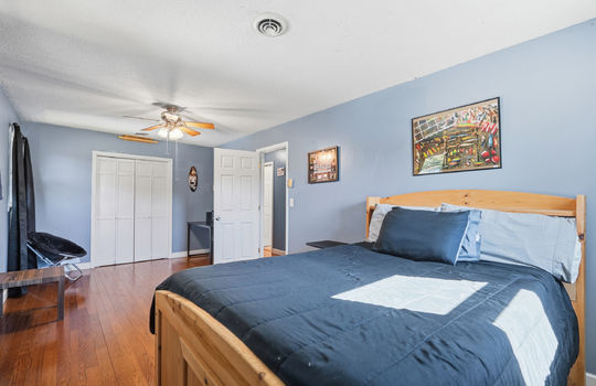 bedroom, hardwood flooring, ceiling fan, closet, door to hallway