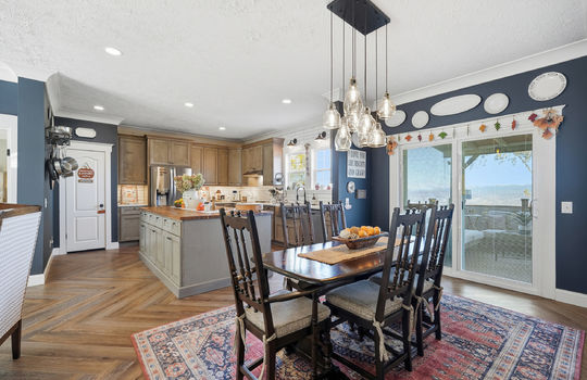 dining room view toward kitchen, luxury vinyl flooring, chandelier, exterior door to back deck, chandelier
