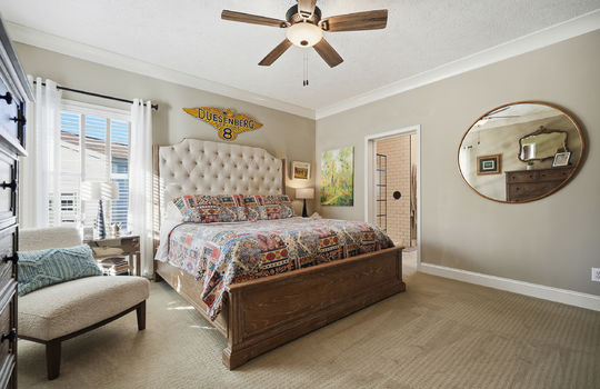 primary bedroom, carpet, ceiling fan, windows, door to primary bathroom