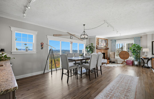 family room, large windows, fireplace, luxury vinyl flooring, mountain views